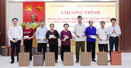 Đồng chí Nguyễn Tuấn Ngọc - Phó Bí thư Thường trực Đảng ủy xã và ông Lê Hồng Phong - Giám đốc Công ty Cổ phần Đầu tư và Phân phối Thế giới Công nghệ TWD trao quà cho các đối tượng