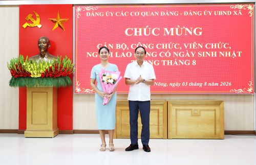 Đồng chí Đỗ Hùng Sơn - Phó Bí thư Đảng ủy, Chủ tịch UBND xã tặng hoa chúc mừng đồng chí Nguyễn Thị Minh Thu - UVBTV, Chủ nhiệm UBKT Đảng ủy xã.