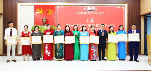 Đồng chí Nguyễn Ngọc Minh và đồng chí Cao Thị Thu Phương - UVBTV, Phó Chủ tịch UBND xã trao Huy hiệu Đảng cho các đồng chí Đảng viên
