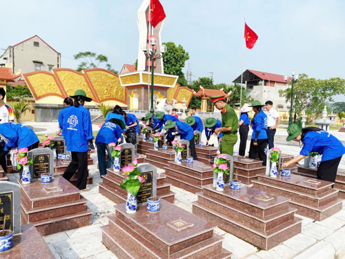 Sinh viên Học viện Nông nghiệp Việt Nam quét dọn lối đi và thay hoa trên các phần mộ tại Nghĩa trang Liệt sĩ