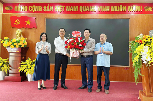 Đồng chí Quách Hải Lý - Bí thư Đảng ủy, Chủ tịch HĐND xã tặng hoa chúc mừng Hội đồng thi tại THPT Tam Nông xã Tam Nông