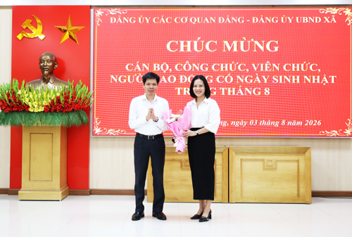Đồng chí Nguyễn Tuấn Ngọc - Phó Bí thư Thường trực Đảng ủy tặng hoa chúc mừng đồng chí Nguyễn Thị Thu Trang - UVBTV, Phó Chủ tịch HĐND xã.