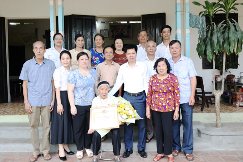 Đồng chí Nguyễn Tuấn Ngọc - Phó Bí thư Thường trực Đảng ủy xã Tam Nông trao Huy hiệu 60 năm tuổi Đảng cho đồng chí Nguyễn Thị Thịch chi bộ 3 (Hương Nộn cũ)