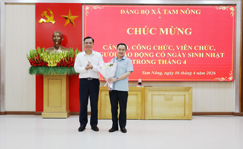 Đồng chí Quách Hải Lý - Bí thư Đảng ủy, Chủ tịch HĐND xã tặng hoa chúc mừng đồng chí Nguyễn Ngọc Minh - UVBTV, Phó Chủ tịch UBND xã có ngày sinh trong tháng 4